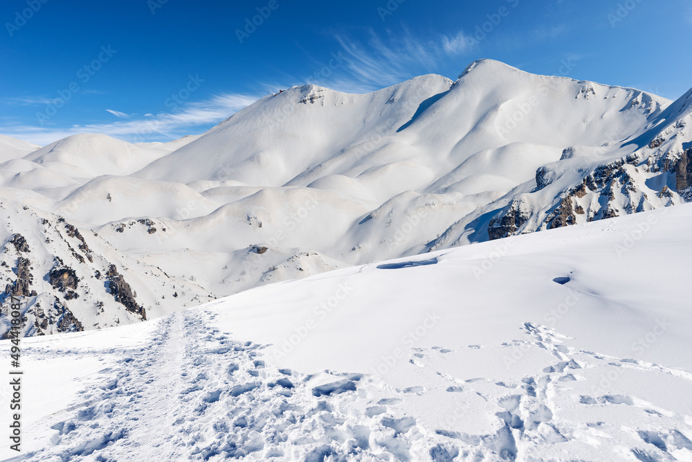 Snowcapped mountain peaks in Italian Alps. Mountain range of Monte Carega (Small Dolomites) in winter, and Lessinia Plateau (Altopiano della Lessinia). Veneto and Trentino Alto Adige, Italy, Europe.
