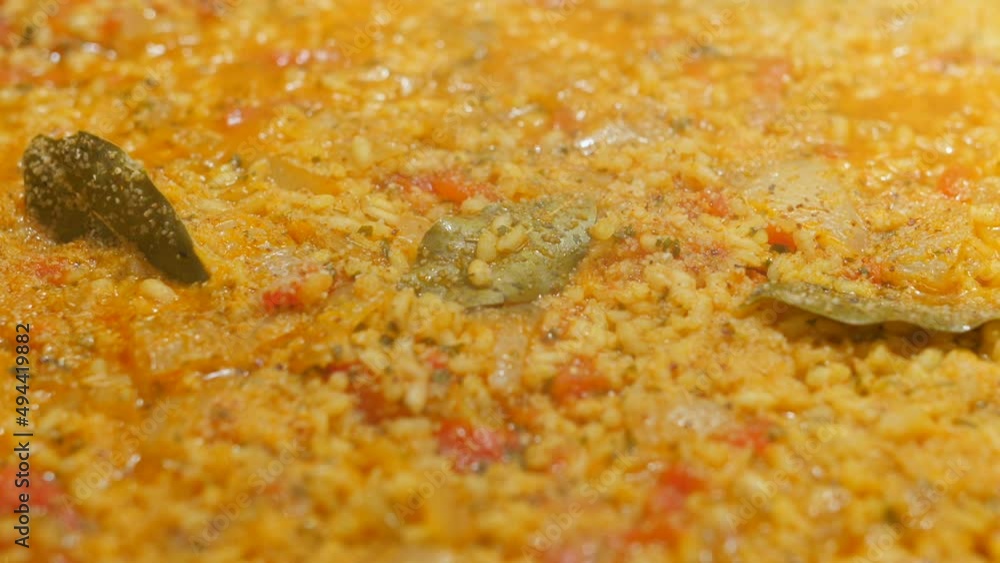 Seafood Paella boiling in a large hot pan. Close up view of paella in a pan cooked at home with steam coming out. Seafood Paella boiling in a large hot pan. Close up view of paella in a pan cooked at home with steam coming out.