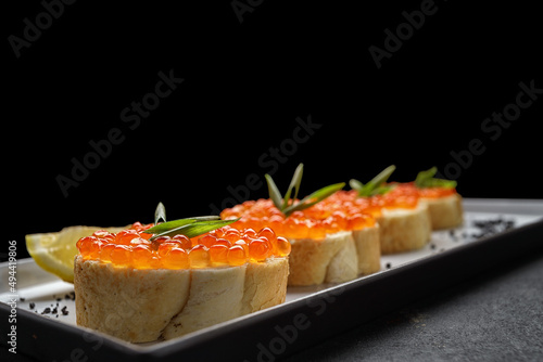 Bruschetta with red caviar, with lemon and green onions