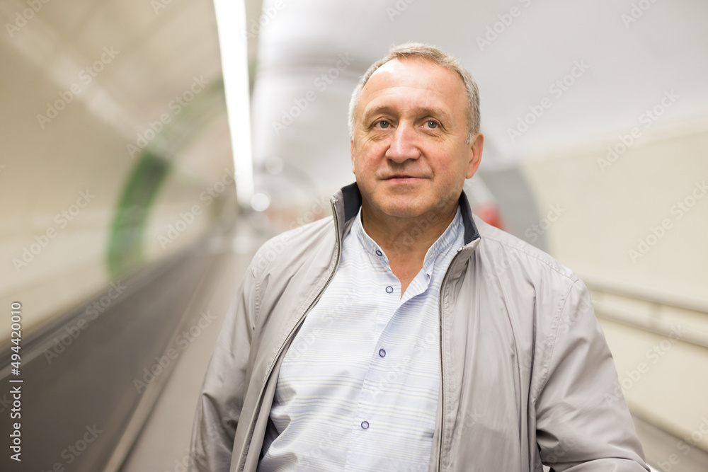 Fototapeta premium Middle aged man on moving walkway