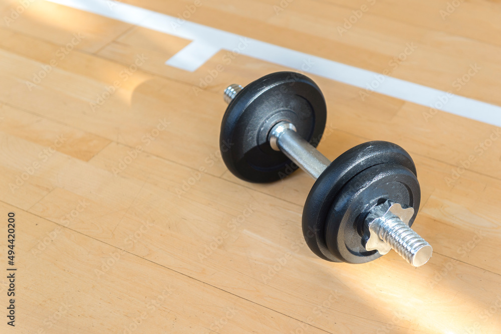 Dumbbell on wooden surface. Concept of rehabilitation and sport training equipment Dumbbell on wooden surface. Concept of rehabilitation and sport training equipment