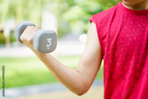 Fotografie Active Asian young man doing a weightlifting by using dumbbell, beginner muscular bodybuilder