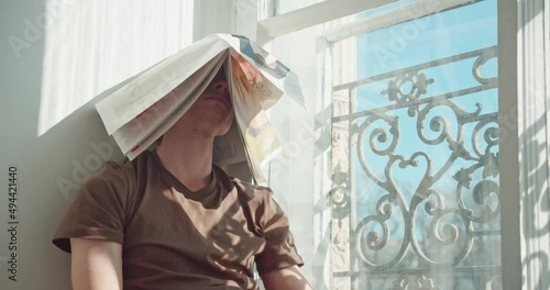 the man covered his head with the newspaper, tired of fake news and the endless flow of information. rests closed from the sun. isolation from propaganda. 