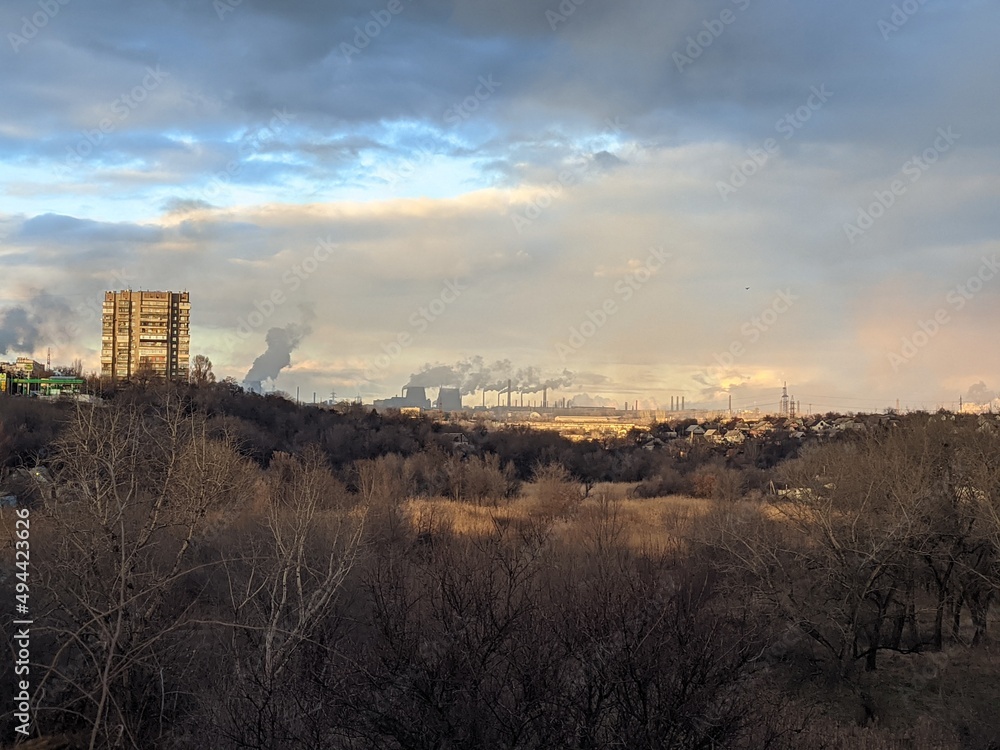 Naklejka premium view of the smoking factories, workshops. Metallurgy. Sunset. Gray sky with smog. Ecological problem