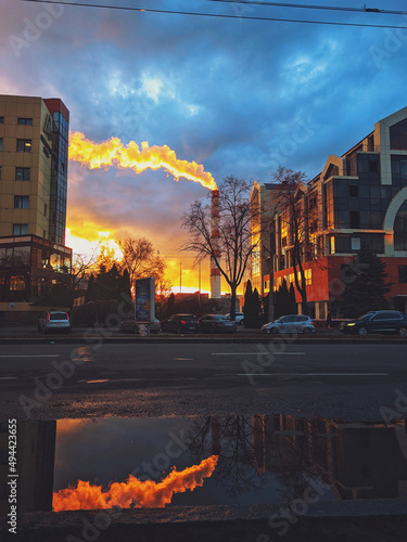 Beautiful reflection of the sunset sky in the puddle in the city road. Ukraine, Zaporizhzhia