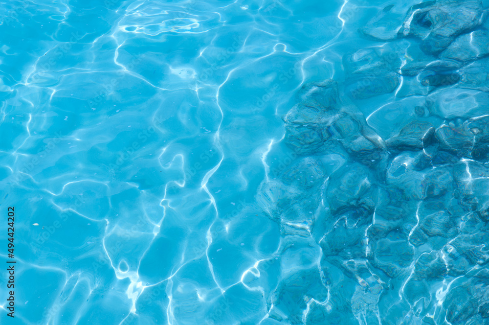 Water background, turquoise shallow sea water. Beautiful texture of sun glare on the water. Water background, turquoise shallow sea water. Beautiful texture of sun glare on the water.