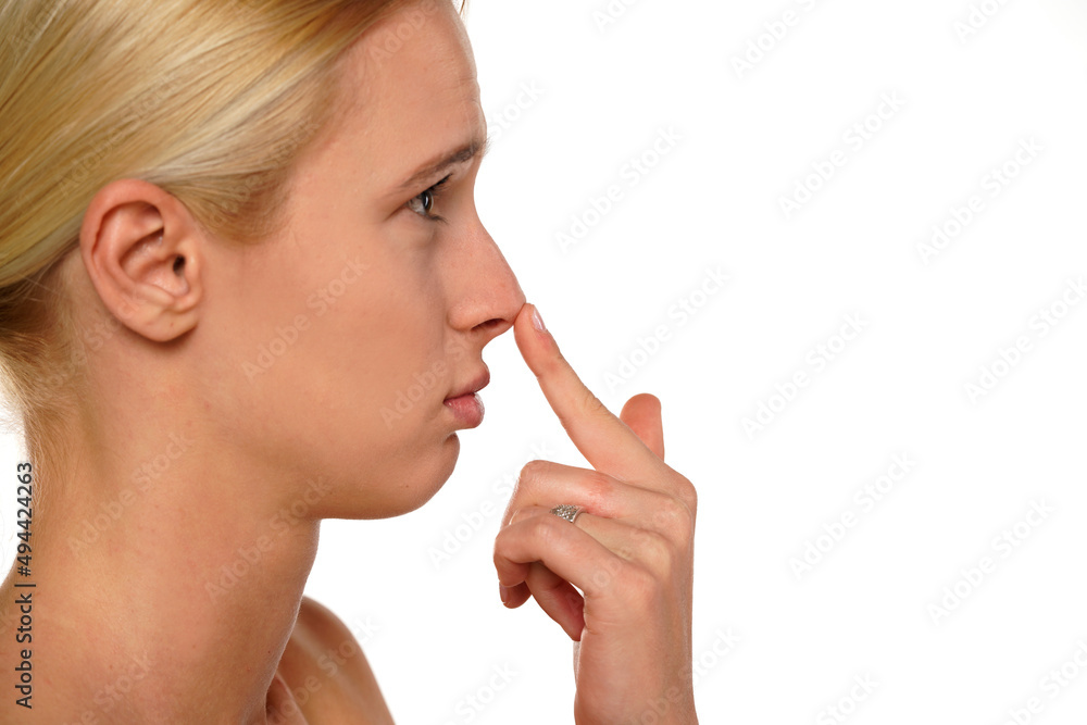 Young sad woman touches her nose with her finger Young sad woman touches her nose with her finger
