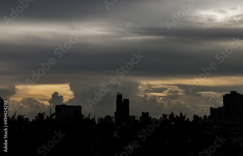 Beautiful clouds with sunshine through the cloud in the sky evening over large metropolitan city skyline. Copy space, No focus, specifically.