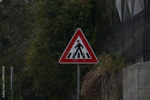 Segnale stradale triangolare di pericolo, che indica un passaggio di pedoni photo