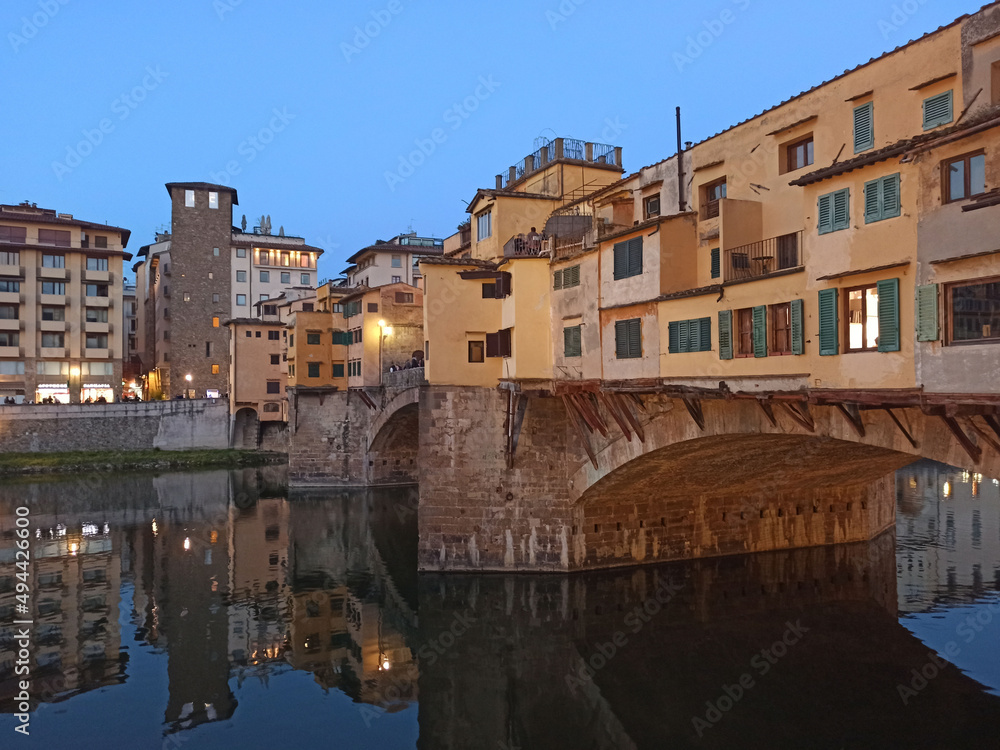 Italia, Toscana, Firenze, il Ponte Vecchio e fiume Arno con le luci della sera.