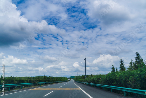 Asphalt expressway on a summer day with clouds