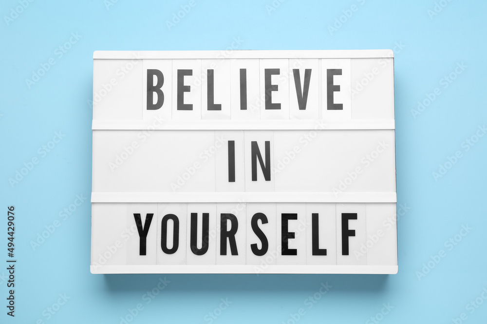 Lightbox with motivational quote Believe in Yourself on light blue background, top view Lightbox with motivational quote Believe in Yourself on light blue background, top view