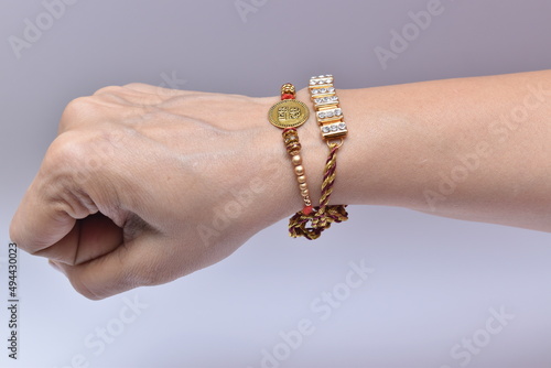 Indian man's hand wearing rakhi on raksha bandhan day. Rakhi is a traditional wrist band which is a symbol of love between brothers and sisters.