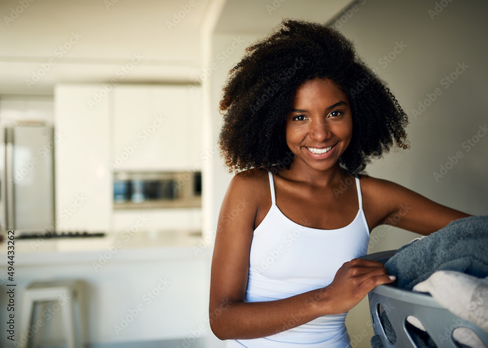 Time to do my daily chores. Cropped shot of an attractive young woman doing the laundry at home. Time to do my daily chores. Cropped shot of an attractive young woman doing the laundry at home.