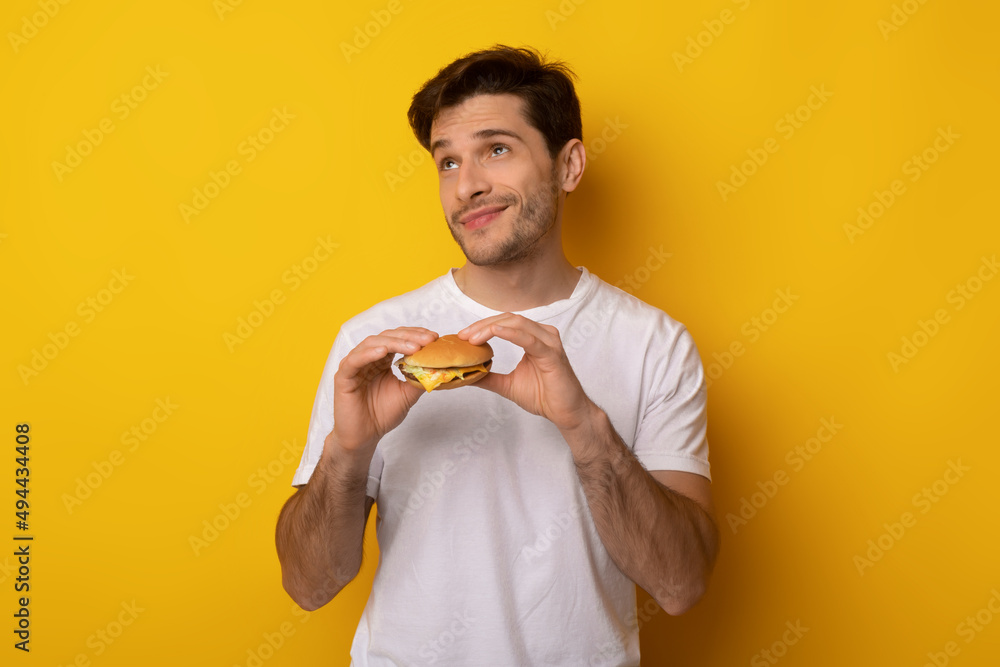 Funny Young Guy Holding Burger At Studio Funny Young Guy Holding Burger At Studio