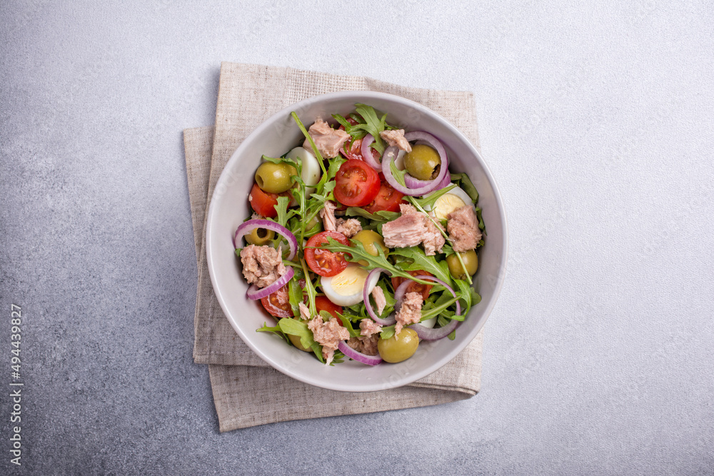 Healthy tuna salad with fresh arugula, cherry tomatoes, quail egg and olives Healthy tuna salad with fresh arugula, cherry tomatoes, quail egg and olives