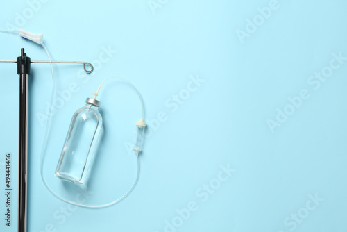 IV infusion set on light blue background, flat lay. Space for text