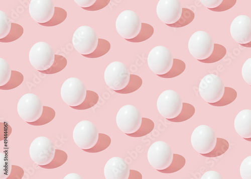 Easter background pattern with white eggs on pink background. Minimal concept. photo