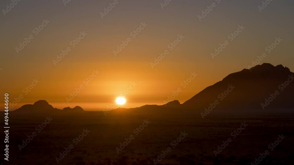 Beautiful Summer Sun Setting With Warm Colors Sky Behind Silhouetted Mountain Of Spitzkoppe In Namibia. - Wide Shot, Static Beautiful Summer Sun Setting With Warm Colors Sky Behind Silhouetted Mountain Of Spitzkoppe In Namibia. - Wide Shot, Static