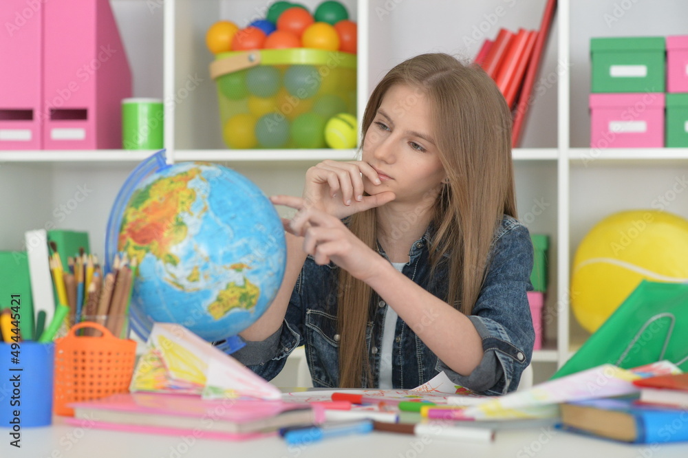 girl siting at table with globe and studying girl siting at table with globe and studying