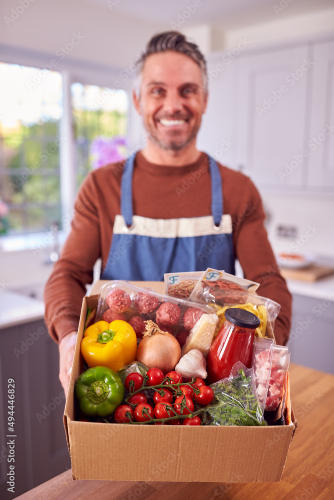 Portrait Of Mature Man Unpacking Online Meal Food Recipe Kit Delivered To Home Portrait Of Mature Man Unpacking Online Meal Food Recipe Kit Delivered To Home
