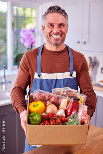 Portrait Of Mature Man Unpacking Online Meal Food Recipe Kit Delivered To Home