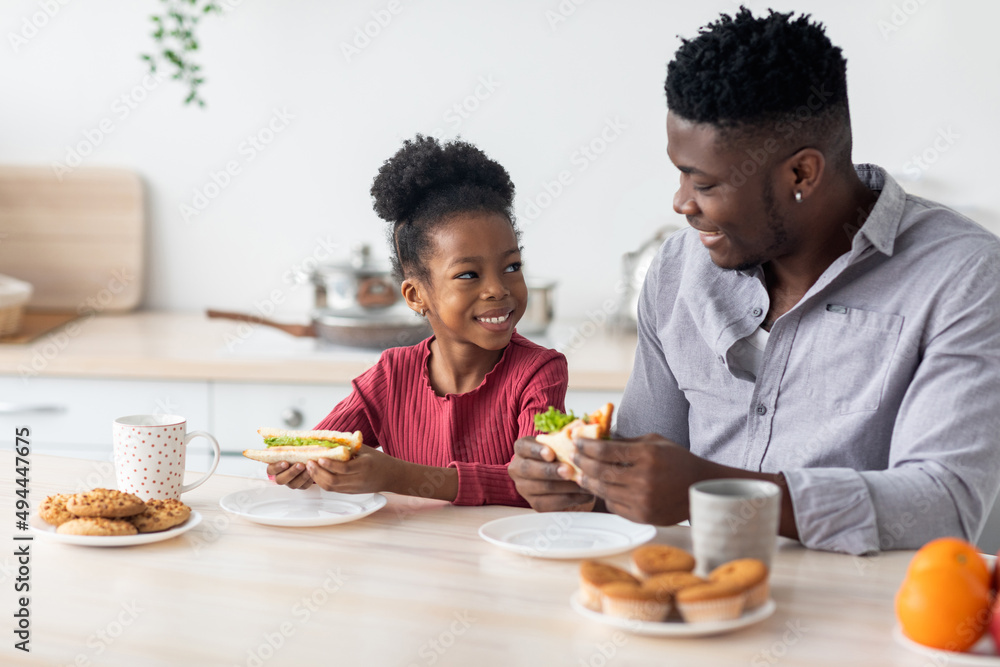 Happy african american father and daughter enjoying healthy breakfast Happy african american father and daughter enjoying healthy breakfast