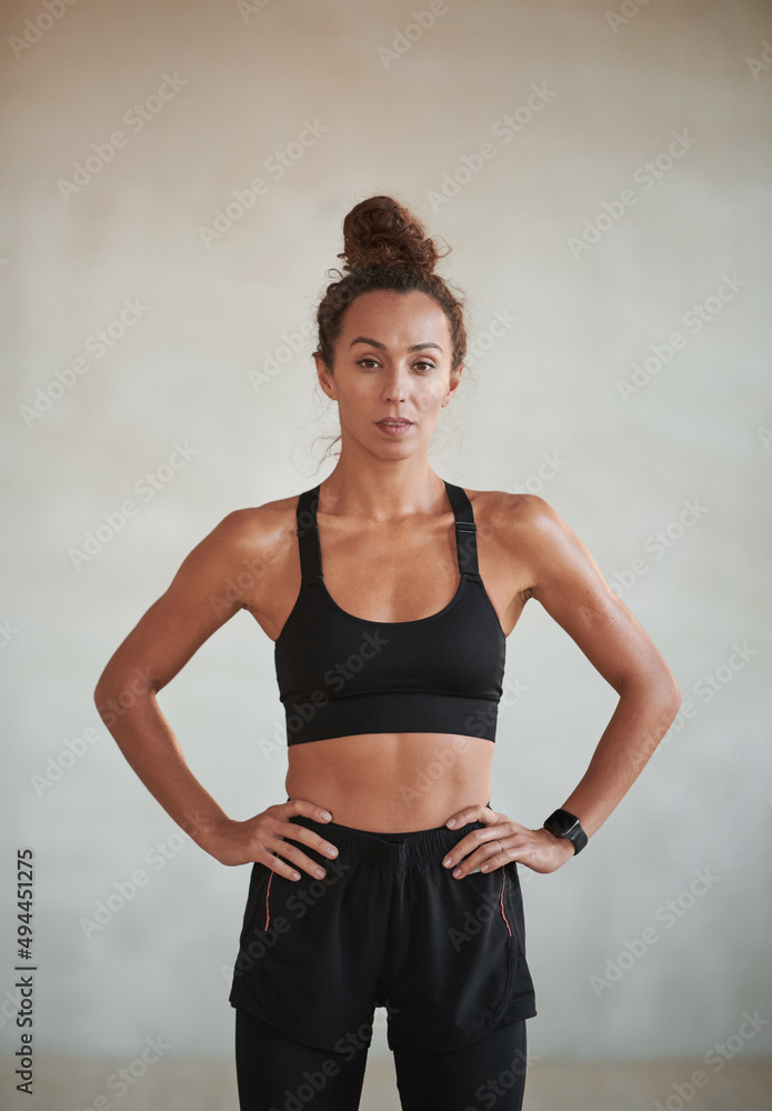 Vertical medium portrait of young adult Caucasian woman with muscular body wearing sports clothes looking at camera Vertical medium portrait of young adult Caucasian woman with muscular body wearing sports clothes looking at camera