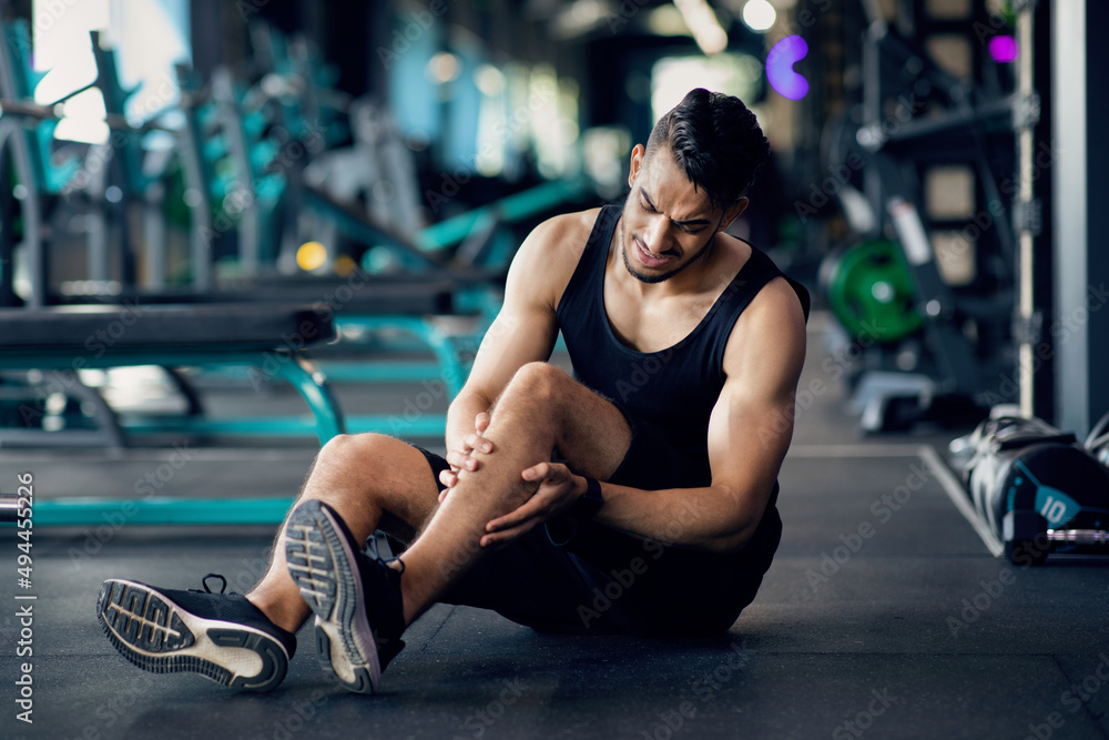 Sport Injury. Arab Male Athlete Suffering Knee Trauma While Training At Gym