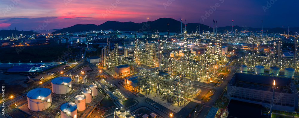 Aerial view. Oil refinery factory and oil storage tank at twilight and night. Banner panorama background	