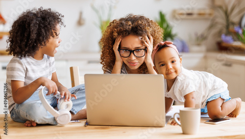 Fotografie Young irritated African-American mother freelancer trying to work while working