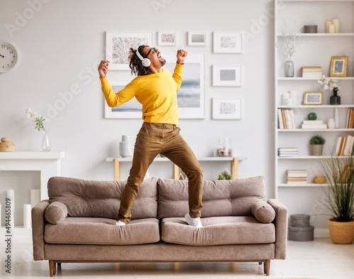 African American meloman dancing on couch photo