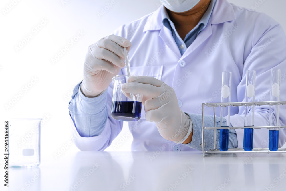 Fototapeta premium Science innovative Male medical or scientific laboratory researcher performs tests with blue liquid in laboratory. equipment science experiments technology Coronavirus Covid-19 vaccine research