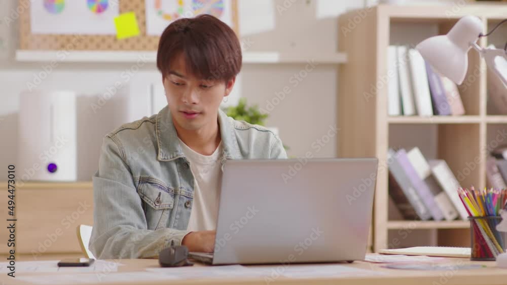 Entrepreneur handsome business asian man wear casual blue shirt working with laptop and talking with customer or business team by mobile phone celebrating at home office.Small Business Startup Concept Entrepreneur handsome business asian man wear casual blue shirt working with laptop and talking with customer or business team by mobile phone celebrating at home office.Small Business Startup Concept