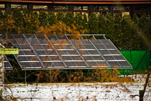 Elektryczny panel słoneczny o dużym formacje ( powierzchni) w ogrodzie , na tle krzewów iglastych . Ekologia , eco , przyjazny klimatowi .