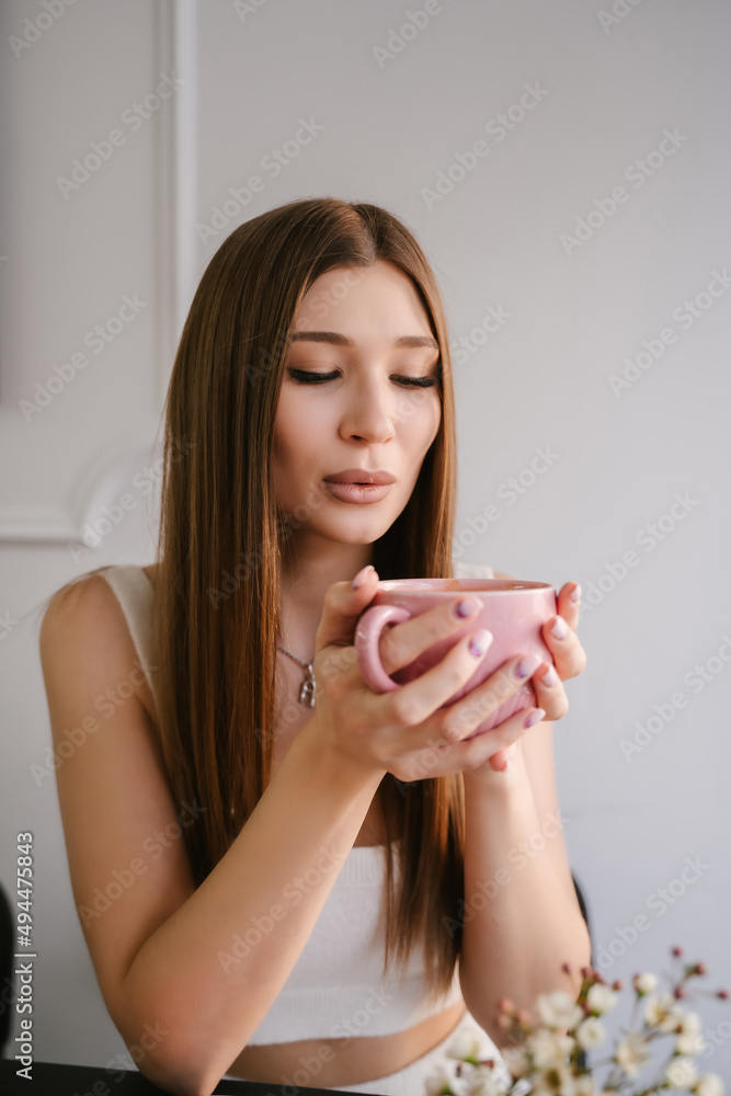 Beautiful young woman drinking delicious coffee in a cafe, smiling brightly Beautiful young woman drinking delicious coffee in a cafe, smiling brightly