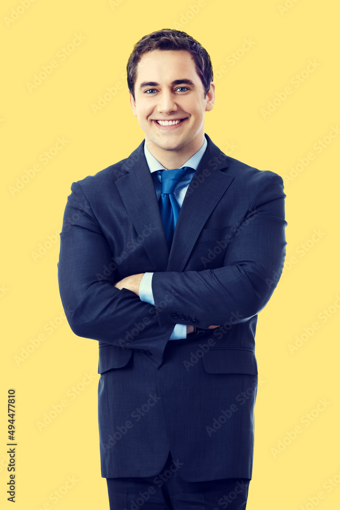 Portrait of smiling middle aged confident businessman, isolated over yellow color background. Happy business man in crossed arms pose at studio. Portrait of smiling middle aged confident businessman, isolated over yellow color background. Happy business man in crossed arms pose at studio.