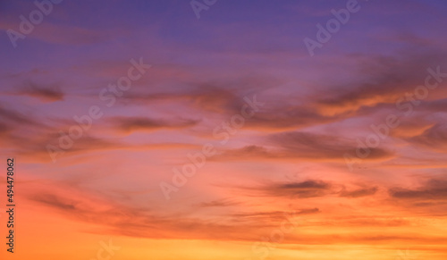Colorful sunset sky in the evening with orange, pink, purple sunlight pastel clouds on golden hour, landscape romantic nature background