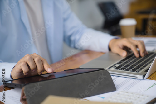 Close up of businessperson using laptop working with digital data.