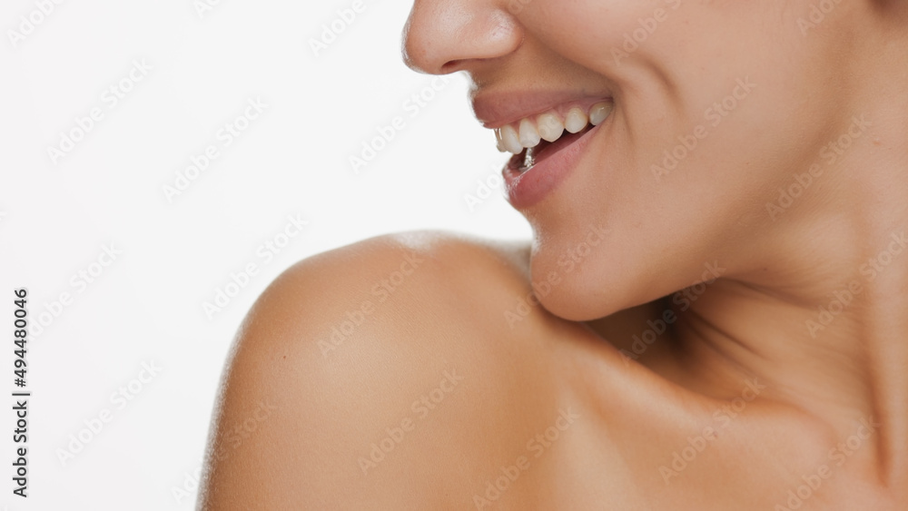 Horizontal big close-up of good-looking female beauty model looks aside and smiles widely on white background | Skin care concept Horizontal big close-up of good-looking female beauty model looks aside and smiles widely on white background | Skin care concept
