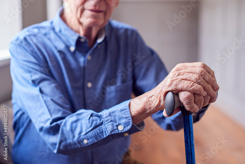 Close Up Of Senior Man At Home Resting Hands On Walking Stick