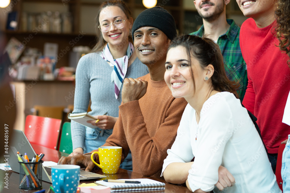 Obraz premium Young multiracial people work together as a team on a project looking at laptop