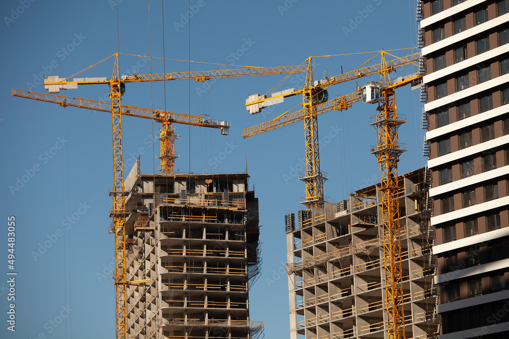 Engineering and Development. Construction cranes and tall unfinished buildings.Modern urban architecture. Engineering and Development. Construction cranes and tall unfinished buildings.Modern urban architecture.