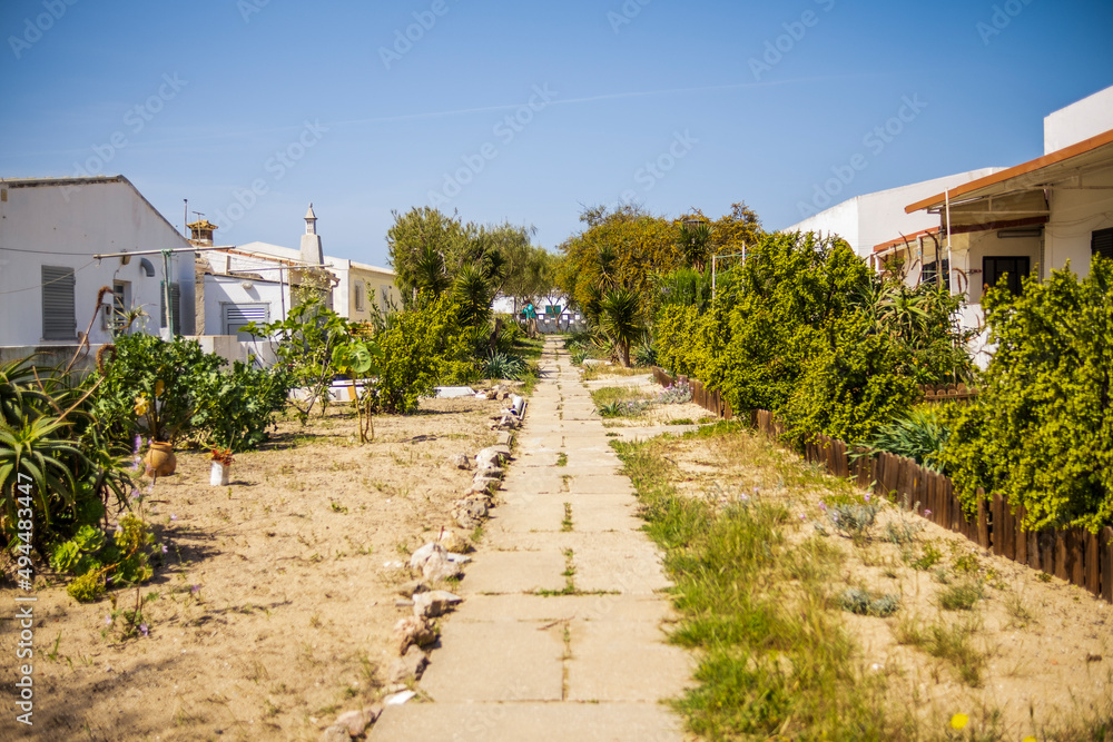Small path between small houses on Farol island, Faro, Algarve, Portugal