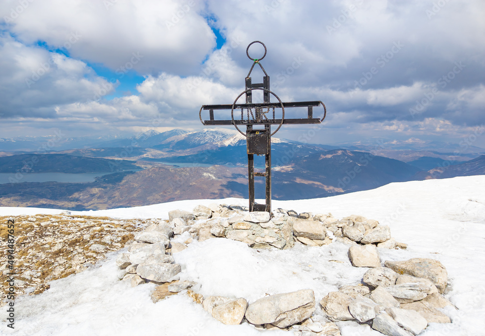 Monte San Franco (Italy) - A panoramic peak mountain summit in central Italy, Abruzzo region, with snow and hiker who practice trekking at high altitude, beside Campotosto lake.