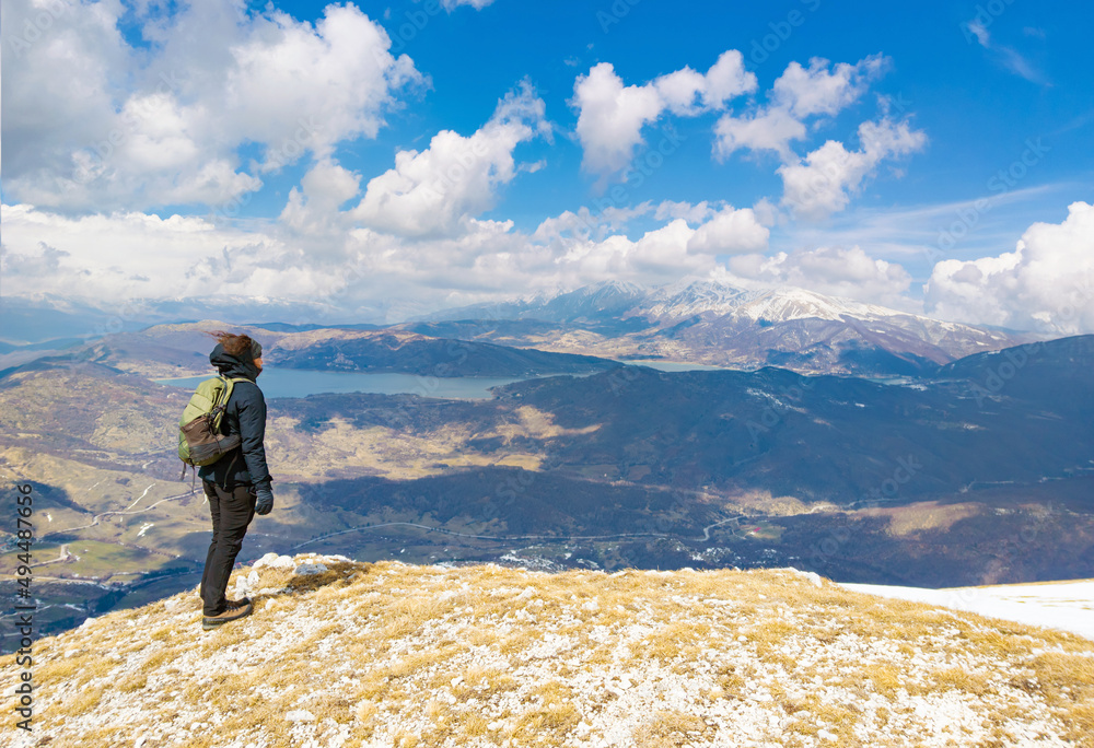 Monte San Franco (Italy) - A panoramic peak mountain summit in central Italy, Abruzzo region, with snow and hiker who practice trekking at high altitude, beside Campotosto lake.