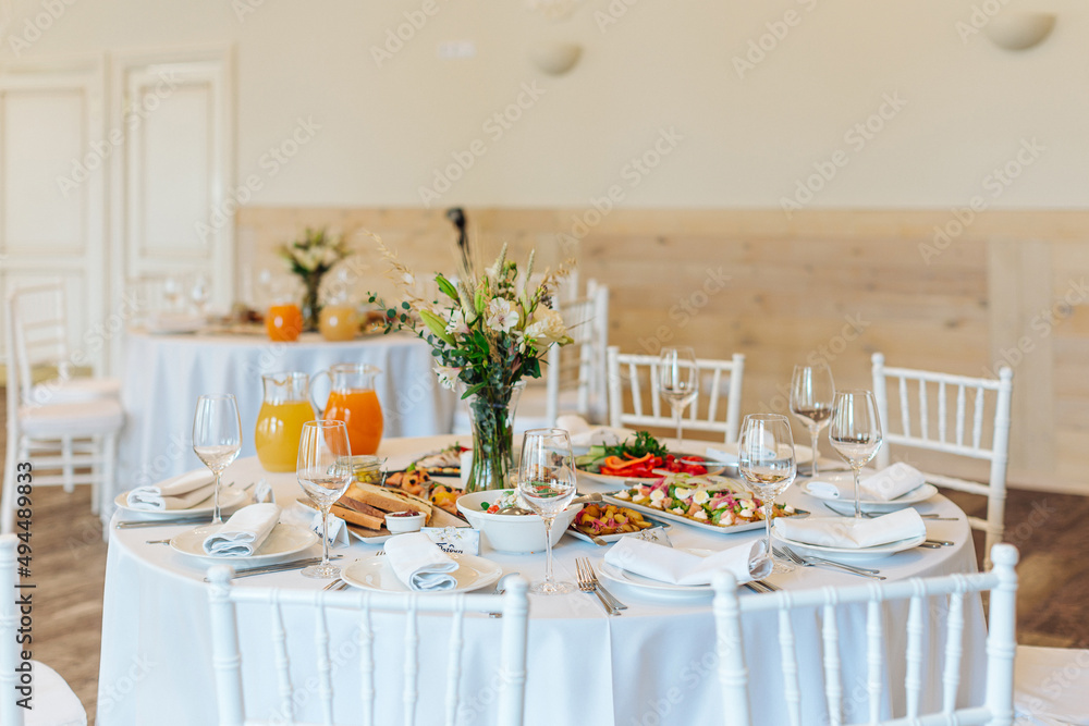 beautifully set tables with glasses and appliances for a wedding or other event