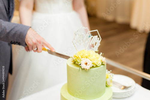 Green wedding cake decorated with flowers