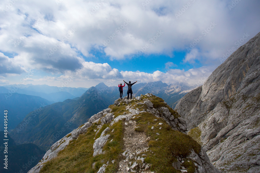 Hikers on hill under Prisojnik peak in Slovenia