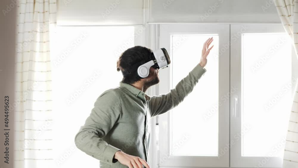 Young man exploring cyberspace in VR goggles at home Young man exploring cyberspace in VR goggles at home